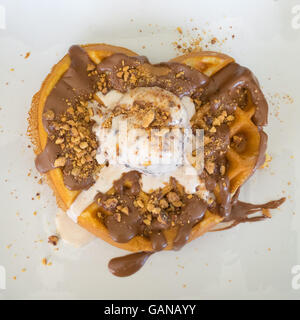 Waffel mit einer Form eines Herzens mit einer Kugel Stracciatella-Eis oben drauf. Stockfoto