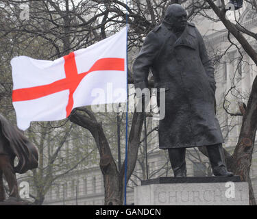 St. Georges Day. Auf dem Parliament Square in London fliegt heute eine St. George's Day-Fahne neben einer Statue von Sir Winston Churchill. Stockfoto