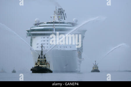 Feuerschlepper begrüßen das größte Kreuzfahrtschiff der Welt, die Independence of the Seas, als sie heute zum ersten Mal in Southampton in Großbritannien ankommt. Das riesige 160,000-Tonnen-Schiff wird den Rest des Jahres von der Stadt aus operieren. Das von Royal Caribbean International gebaute 400-Millionen-Schiff ist zusammen mit ihren Schwesterschiffen Freedom of the Seas und Liberty of the Seas das größte Kreuzfahrtschiff der Welt. Stockfoto