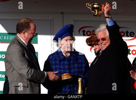 Pferderennen - Cheltenham Festival 2003. Der Besitzer des Best Mate Jim Lewis feiert mit dem Cheltenham Gold Cup, nachdem er die Trophäe von der Queen überreicht wurde Stockfoto