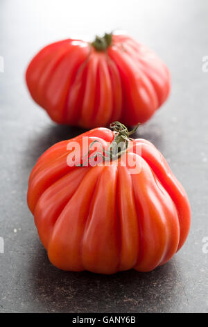 Coeur De Boeuf. Fleischtomaten auf alten Küchentisch. Stockfoto