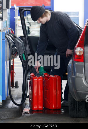 An der Esso-Tankstelle an der Willowbrae Road in Edinburgh füllt ein Mann Kanister. Stockfoto