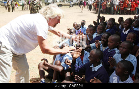 Sir Richard Branson trifft sich mit Schulkindern der Mara-Schule in der Nähe der Masi Mara in Kenia, wo mit Hilfe von Mitgliedern des Virgin Atlantic Flying Club, die jeweils 2,000 Schüler aufgezogen haben, ein neues Schulgebäude errichtet wurde. Stockfoto