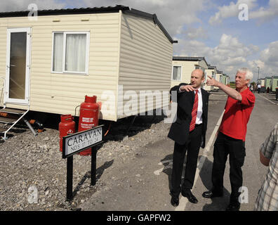 John Healey (links), Minister für Hochwasserwiederherstellung, mit dem Nachbarschaftsmanager Pat Hanagan auf dem Caravangelände in toll Bar, in der Nähe von Doncaster, wo er Bewohner traf, die nach den Überschwemmungen des letzten Jahres noch in Wohnwagen leben, während ihre Häuser repariert wurden. Stockfoto