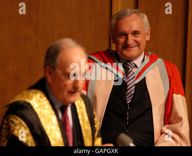 Der kürzlich pensionierte irische Taoiseach Bertie Ahern (rechts) erhält seine Ehrendoktorwürde vom Kanzler der Queen's University, dem ehemaligen US-Senator George Mitchell, in Belfast. Stockfoto