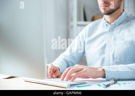Abgeschnitten Bild eines jungen Geschäftsmann arbeiten mit Computer im Büro Stockfoto