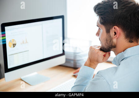 Seitenansicht eines jungen sicher gut aussehend Geschäftsmann arbeiten am Laptop im Büro Stockfoto