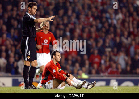 Fußball - UEFA Champions League - Viertelfinale - zweite Etappe - Manchester United gegen Real Madrid. Ryan Giggs von Manchester United (r) sitzt verletzt, nachdem er gegen Fernando Hierro von Real Madrid angegangen wurde (l) Stockfoto