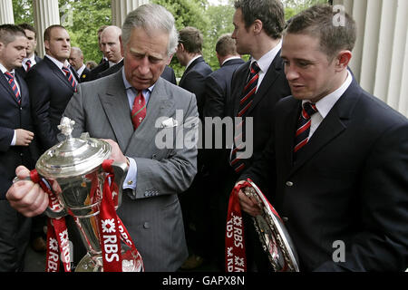 Prinz Charles (links) hält die RBS Six Nations Trophäe, während er mit dem walisischen Rugby Union Spieler Shane Williams während eines Empfangs mit dem walisischen Rugby Team im Clarence House in London spricht. Stockfoto