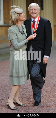 Sir Michael Parkinson, begleitet von seiner Frau Lady Mary Parkinson, nachdem er seine Ritterschaft von Königin Elizabeth II. Im Buckingham Palace, London, erhalten hatte. Stockfoto