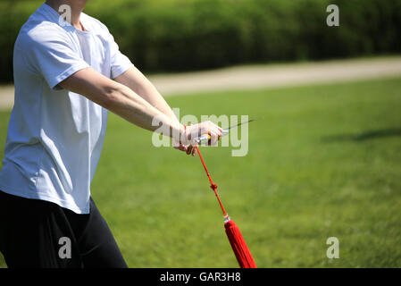 Tai Chi Kampfkunst Sportler Experte macht Bewegungen mit scharfen Schwert Stockfoto