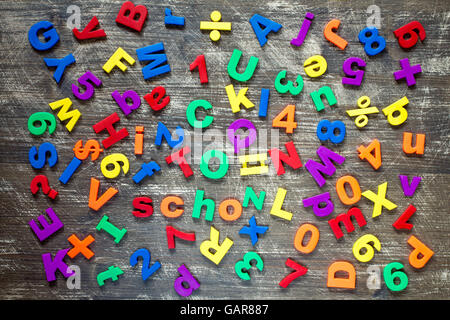 Hintergrund von bunte magnetische Buchstaben und Ziffern über einem hölzernen Hintergrund Stockfoto