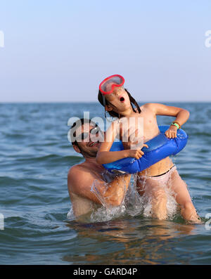 Vater und Tochter spielen im Wasser des Meeres im Sommer Stockfoto