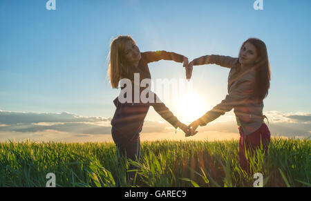 Sonnenuntergang Herz von zwei Mädchen Stockfoto