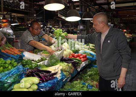 Einem bunten Obst und Gemüse Markt im Bereich Tianzifang, das ehemalige französische Viertel, kauft hier ein Mann Salat. Shanghai. Stockfoto