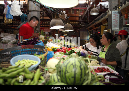 Zwei Frauen kaufen Gemüse in den bunten Obst und Gemüse Markt in Tianzifang, das ehemalige französische Viertel. Shanghai. Stockfoto