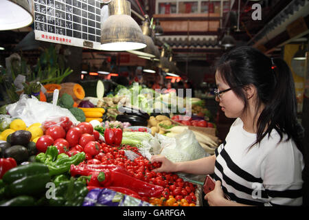 Einen bunten Obst und Gemüse Markt im Bereich Tianzifang, kauft hier eine Frau Cherry-Tomaten Gemüse Stand. Shanghai, China. Stockfoto