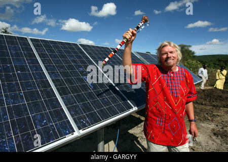 Sir Richard Branson steht vor der Solarpaneelanlage, die mit finanzieller Hilfe von Virgin Atlantic gebaut wurde, um eine Masi Mara Grundschule und die lokale Gemeinschaft in Kenia mit Wasser zu versorgen. Stockfoto