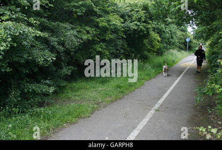 Eine Frau geht an der Szene an der Throop Road in Bournemouth, Dorset, vorbei, wo der Leichnam eines Mannes in einem Koffer begraben gefunden wurde. Stockfoto