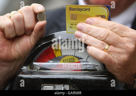 Robert Barnes, Chef von Parkeon, der die Parkplatzmesser in London herstellt, hält ein Stück mit sechs Pence und eine Kreditkarte neben einem originalen 1958 Duncan Single Space Parking Meter am Grosvenor Square in London. Stockfoto
