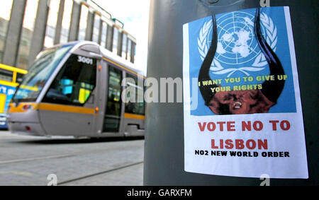 Eine Luas-Straßenbahn fährt an einem Plakat vorbei, auf dem vor dem Referendum in Dublin ein Nein zur Abstimmung gefordert wird. Stockfoto