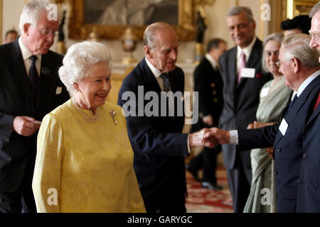 Der Herzog von Edinburgh, der heute seinen 87. Geburtstag feiert, begrüßt den ehemaligen Gouverneur der Bank of England, Sir Edward George (2. Rechts), während er an einem Empfang mit Königin Elizabeth II. Teilnimmt, um eine weltweite Kampagne für kostenlose Grundschulbildung im Buckingham Palace im Zentrum von London zu feiern. Stockfoto