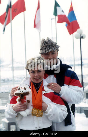 (L-R) die Briten Jayne Torvill und Christopher Dean zeigen ihre Goldmedaillen mit Hilfe von Vucko, dem Wolf, dem offiziellen Maskottchen der Olympischen Spiele in Sarajevo Stockfoto