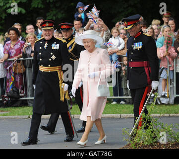 Die britische Königin Elizabeth II. Bereitet sich auf die Enthüllung des Eingangssteins der neu umbenannten Royal Artillery Barracks, Larkhill, Salisbury, Wiltshire, vor. Sie wird von Meister Gunner, Alex Harley (links) und Colonel Ian Tinsley (rechts) begleitet. Stockfoto