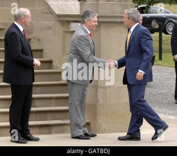 Sinn Fein Stellvertretender erster Minister Martin McGuinness, links und erster Minister Peter Robinson, Mitte, grüßen US-Präsident George Bush, rechts, am zweiten Tag des offiziellen Besuchs des Präsidenten im Vereinigten Königreich im Stormont Castle in Belfast. Stockfoto