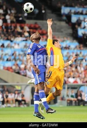 Rumäniens Daniel Niculae (r) und Frankreichs Eric Abidal springen beide Hoch in einem Kampf um den Ball Stockfoto