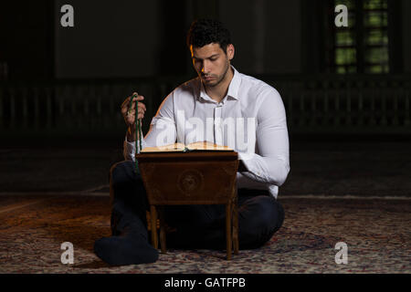 Bescheidenen muslimischer Mann liest den Koran In der Moschee Stockfoto