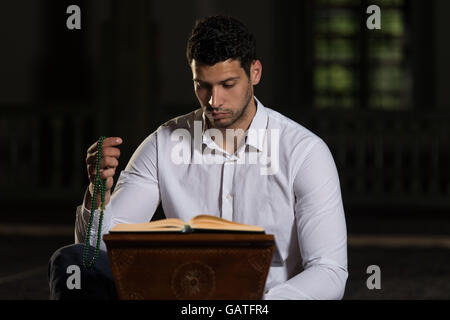 Bescheidenen muslimischer Mann liest den Koran In der Moschee Stockfoto