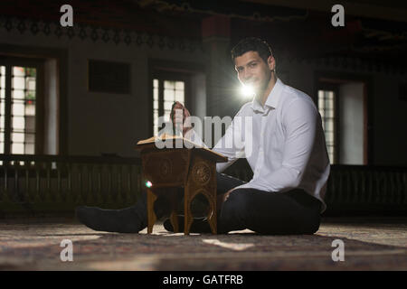 Bescheidenen muslimischer Mann liest den Koran In der Moschee Stockfoto