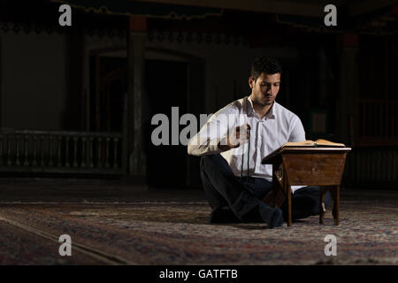 Bescheidenen muslimischer Mann liest den Koran In der Moschee Stockfoto