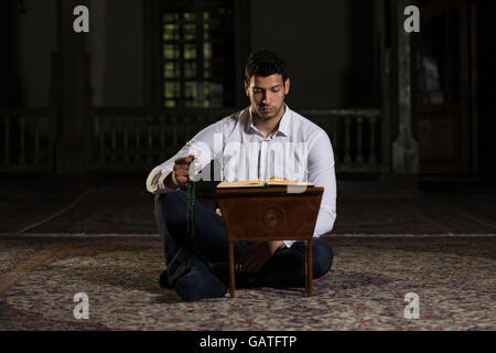 Bescheidenen muslimischer Mann liest den Koran In der Moschee Stockfoto
