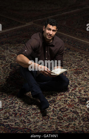 Bescheidenen muslimischer Mann liest den Koran In der Moschee Stockfoto