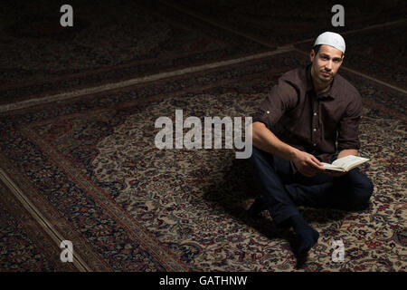 Bescheidenen muslimischer Mann liest den Koran In der Moschee Stockfoto