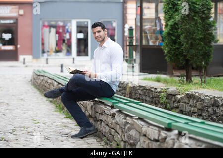 Bescheidenen muslimischer Mann liest das Koran im freien Stockfoto