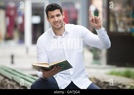 Bescheidenen muslimischer Mann liest das Koran im freien Stockfoto