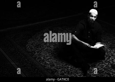 Bescheidenen muslimischer Mann liest den Koran In der Moschee Stockfoto