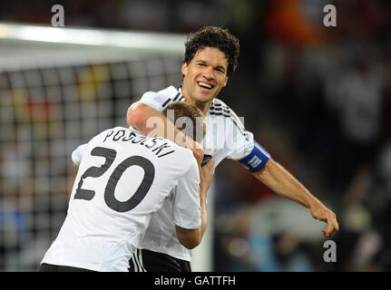 Fußball - UEFA-Europameisterschaft 2008 - Viertelfinale - Portugal gegen Deutschland - St. Jakob-Park. Der deutsche Michael Ballack feiert mit seinem Teamkollegen Lukas Podolski das dritte Tor des Spiels Stockfoto