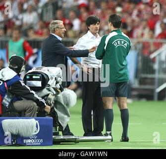 Fußball - UEFA-Europameisterschaft 2008 - Gruppe B - Österreich - Deutschland - Ernst Happel-Stadion. Österreichs Coach Josef Hickersberger (l) und Deutschlands Coach Joachim Low (c) sprechen mit dem 4. Offiziellen Paolo Calcagno auf der Touchline Stockfoto