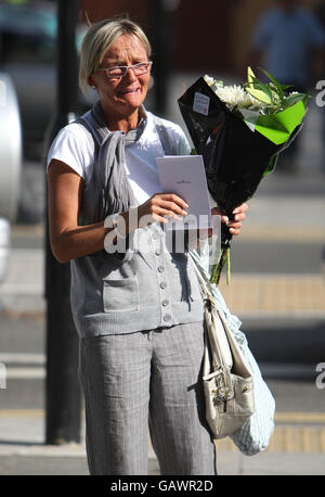 Ein Trauerling kommt, um Blumen an der Szene in Islington, London, zu legen, wo der Teenager Ben Kinsella ermordet wurde. Stockfoto