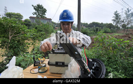 Yueyang, Chinas Hunan Provinz. 6. Juli 2016. Elektriker repariert ein Ladegerät im Baishiling Village in Yueyang Stadt, Zentral-China Provinz Hunan, 6. Juli 2016. Von Dauerregen betroffen, erlitt das Dorf eine starke Staunässe. Mehr als 400 Einwohner haben derzeit verlegt. Bildnachweis: Lange Hongtao/Xinhua/Alamy Live-Nachrichten Stockfoto