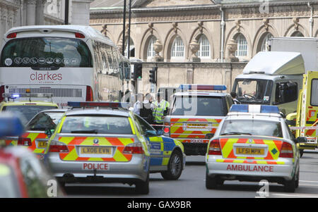 Rettungsdienste nehmen am Ort eines Unfalls mit einem Polizeimotorrad und einem Lastwagen am Buckingham Gate im Zentrum von London Teil. Stockfoto