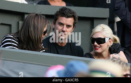 Gwen Stefani (rechts) und Gavin Rossdale (Mitte) beobachten die Action auf dem Center Court während der Wimbledon Championships im All England Lawn Tennis Club, Wimbledon, London. Stockfoto