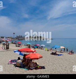 Sonnenanbeter genießen Sie die Sonne am Strand in Fuengirola, Costa Del Sol, Spanien Stockfoto