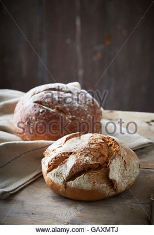 Zwei Handwerker gebackene Brote auf dunklem Hintergrund mit Leinen Stockfoto