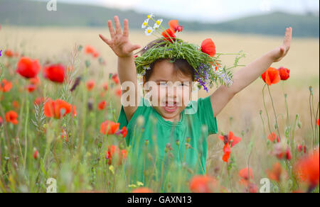 Nettes Kind Mädchen in einem Mohnfeld Stockfoto