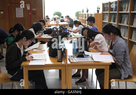 Junge Chinesen Menschen sitzen und lesen in der Bibliothek. Bibliothek von Shenzhen, Shenzhen, China. 05.05.2016. Stockfoto